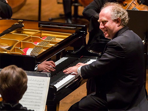 Jeffrey Kahane plays a grand piano with an orchestra